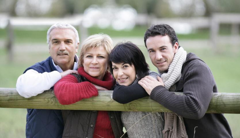 family-leaning-on-a-wooden-fence-post