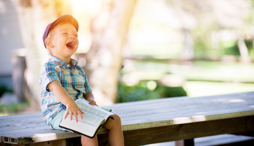 child-laughing-on-a-picnic-bench