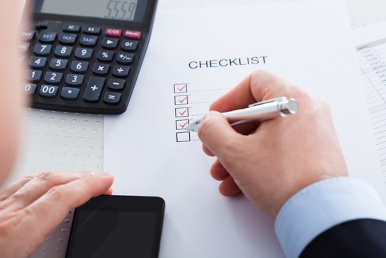 an-accountant-using-a-calculator-and-checklist