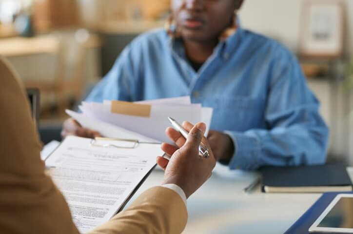Person handing over financial documents for review during a tax consultation