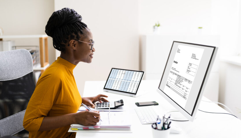 Accountant wearing a yellow shirt working on a computer