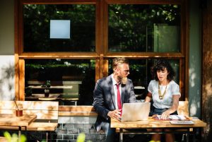 an-accountant-helping-a-client-manage-their-trust-while-sitting-outside-of-a-shop