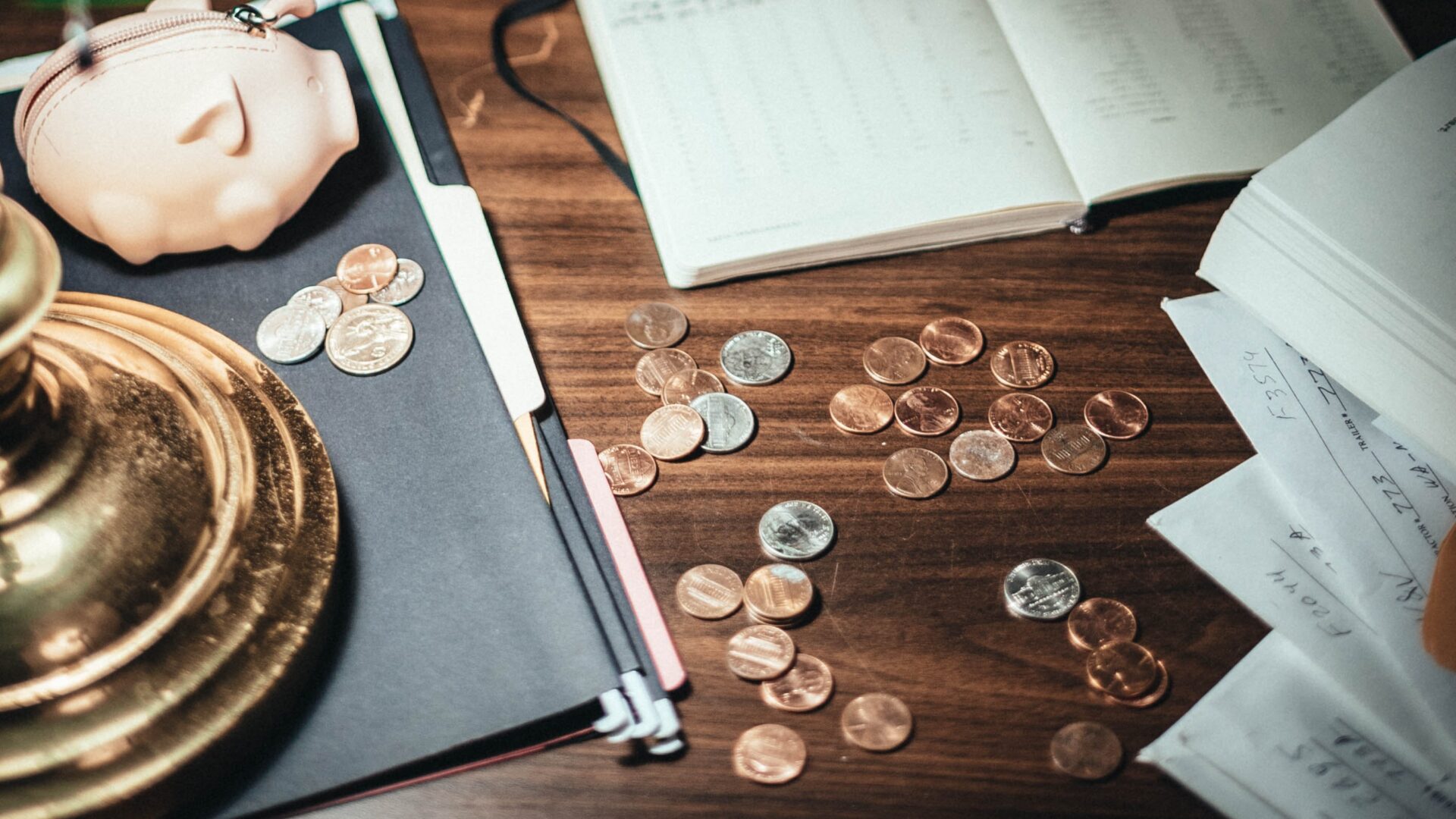 Wood desk with coins, piggy bank and accounting documents