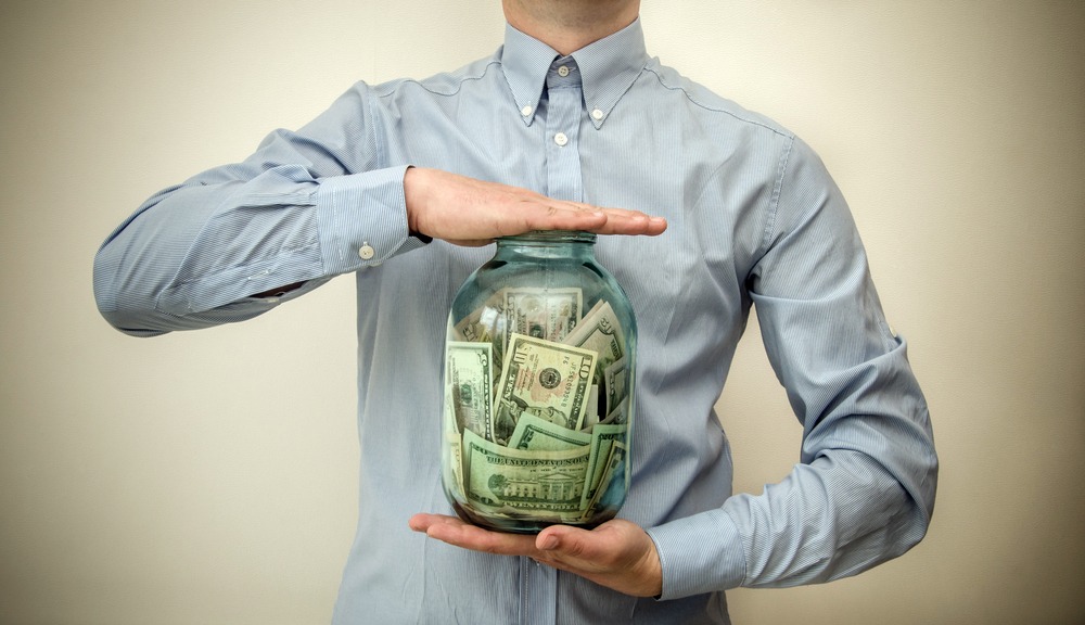 man holding a jar full of money