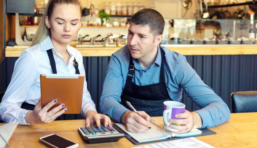 Small family restaurant owners discussing finance calculating bills and expenses of new small business